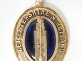 une image représentant une médaille bleue et dorée avec une tour horloge au centre