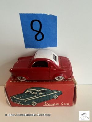 une petite voiture rouge posée sur une boîte rouge