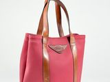 un sac fourre-tout rose et marron posé sur une surface blanche