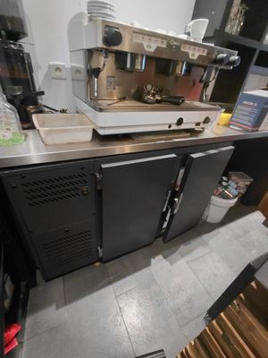une machine à café posée sur le plan de travail d'une cuisine