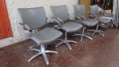 quatre chaises de bureau alignées en rang devant un mur