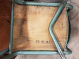 a chair that has a wooden seat and a metal frame