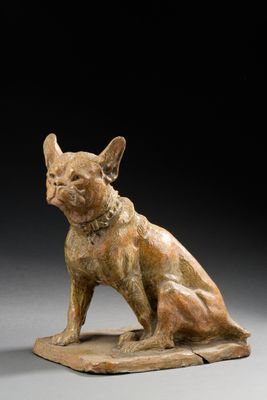 une photo représentant une statue de chien assis sur un bloc de bois
