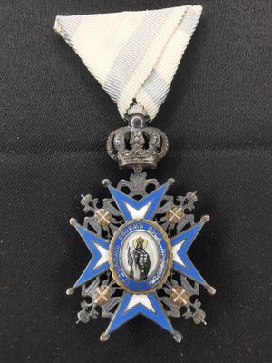 une médaille bleue et blanche sur laquelle figure une couronne