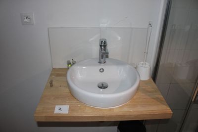 a white sink sitting on a wooden counter in a bathroom