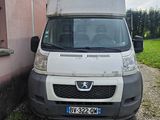 une camionnette blanche garée devant un immeuble rose