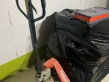 a pile of luggage and a hand truck in a room