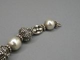 un gros plan sur un bracelet composé de perles et de perles en argent