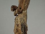 an old wooden statue of a man holding a bird in his hand