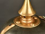 a black and gold vase with a gold top on a table