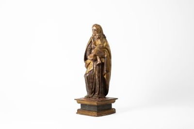 une vieille statue représentant une femme tenant un enfant dans ses bras, posée sur un socle