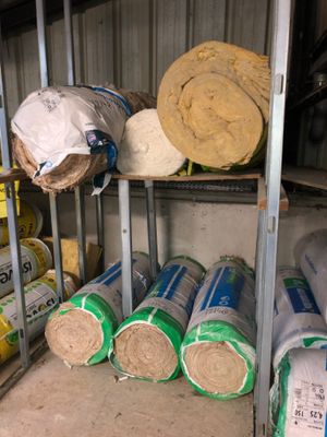 many rolls of insulation on the shelves in the garage