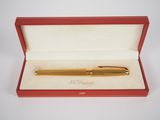 a gold pen in a red box with a white background