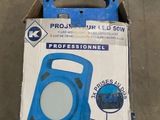 emballage d'un souffleur portable bleu et blanc posé sur un sol en béton