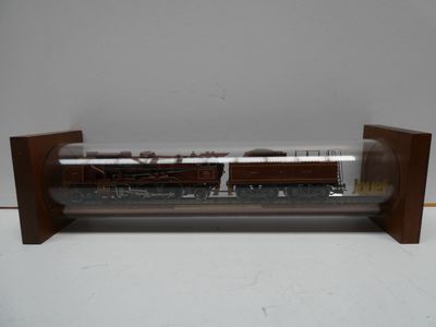 un train miniature dans une vitrine posée sur une table