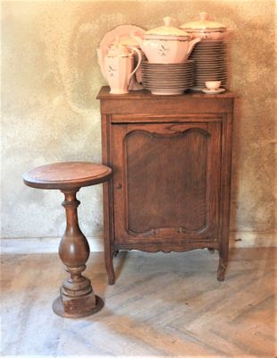 a small table with plates and cups on it next to a cabinet
