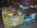 Plusieurs cartons de dentifrice sont empilés sur une palette dans un magasin