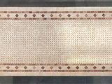 the rug is made of beige and brown tiles and has a border of small squares