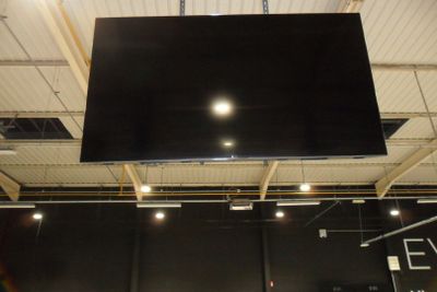 un grand téléviseur suspendu au plafond dans une pièce