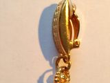 a picture of a gold plated charm on a white surface