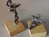 pair of silver figurines of a boy and a girl on a marble base