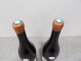 two bottles of wine are sitting on a table next to each other