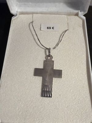 sterling silver cross pendant with a sunburst design on a chain