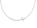 un collier avec une croix en diamant suspendue à une chaîne, sur fond blanc