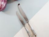 a knife and a knife on a cutting board next to an eggplant and an eggplant