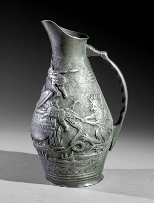a green vase with a bird on it sitting on a table