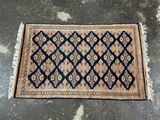 un tapis bleu et beige posé sur un sol en béton