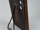 an old metal picture frame with a bird on it