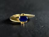 an image of a gold ring with a blue stone on it