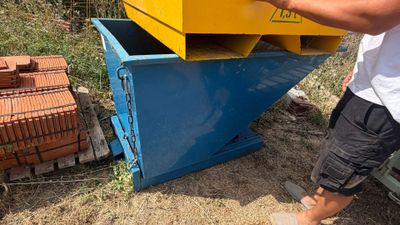 un homme qui se tient à côté d'une boîte jaune