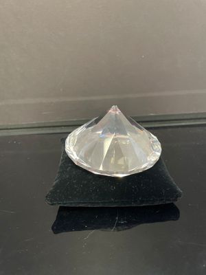 un objet en verre transparent posé sur une surface noire