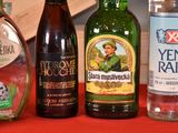 several bottles of alcohol are lined up on a red table