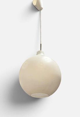 un gros plan d'une lampe blanche accrochée à un mur