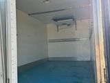 un camion dont une porte est ouverte et dont le plancher est bleu
