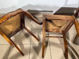 two wooden chairs sitting next to each other on a tile floor