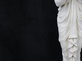 a white statue of a woman with a flower in her hair