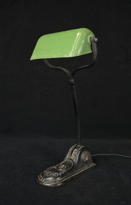 une lampe de bureau verte sur laquelle sont posées une paire de chaussures
