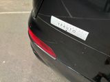 a sticker on the back of a car that is parked in a parking lot