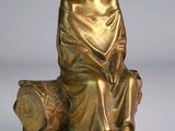statue en bronze représentant une fillette assise sur un rocher avec un chien