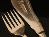 two forks and a knife on a black table