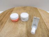 two bottles of cream and a tube of cream on a wooden table