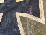an old iron cross painted on the side of a building