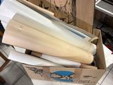 une boîte en carton remplie de papiers et d'autres objets, posée par terre