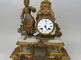 une horloge en or posée sur une table en marbre