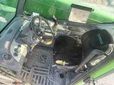 a green car with a steering wheel and a black seat