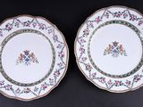 deux assiettes ornées de motifs floraux, posées sur une surface noire